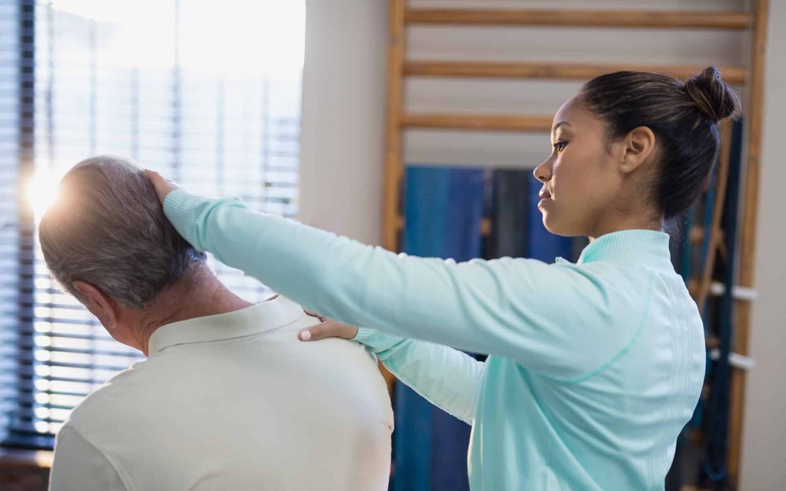 female therapist examining neck of senior male pat 2023 11 27 05 36 20 utc