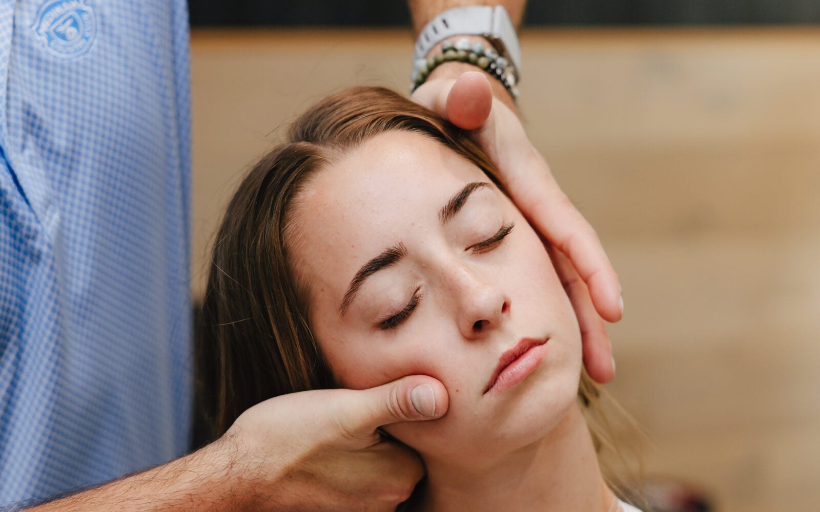 Chiropractor performing a gentle neck and jaw assessment on a patient at Forza Chiropractic