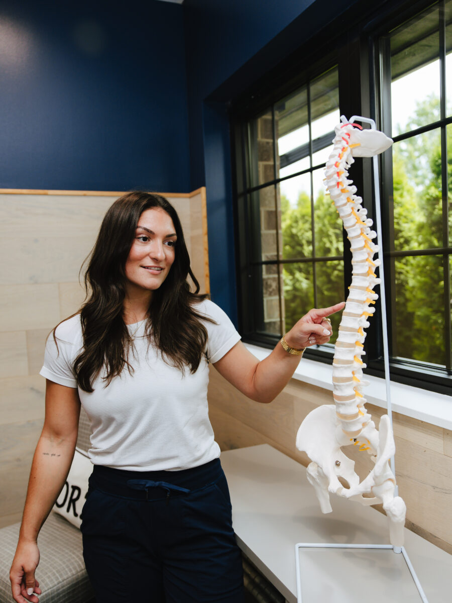 Forza Chiropractic team member holding a full spine model