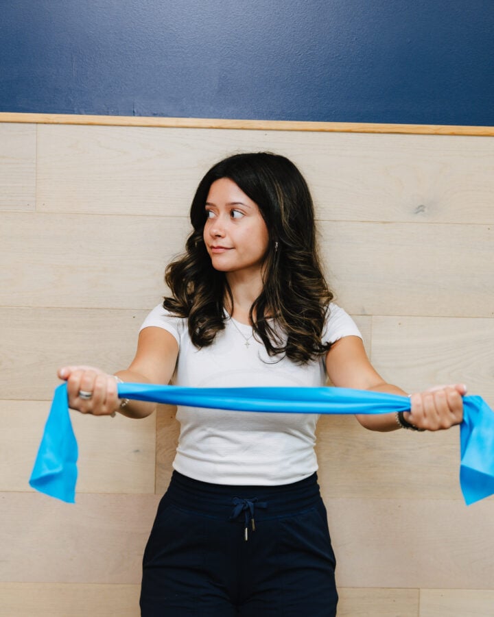 Patient performing a resistance band stretch for posture strengthening