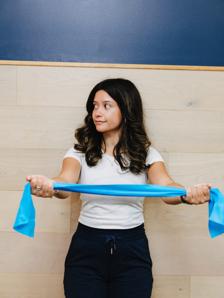 Patient performing a resistance band stretch for posture strengthening