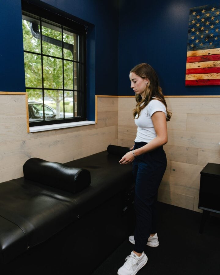 Patient seated on a treatment table at Forza Chiropractic in Arlington Heights